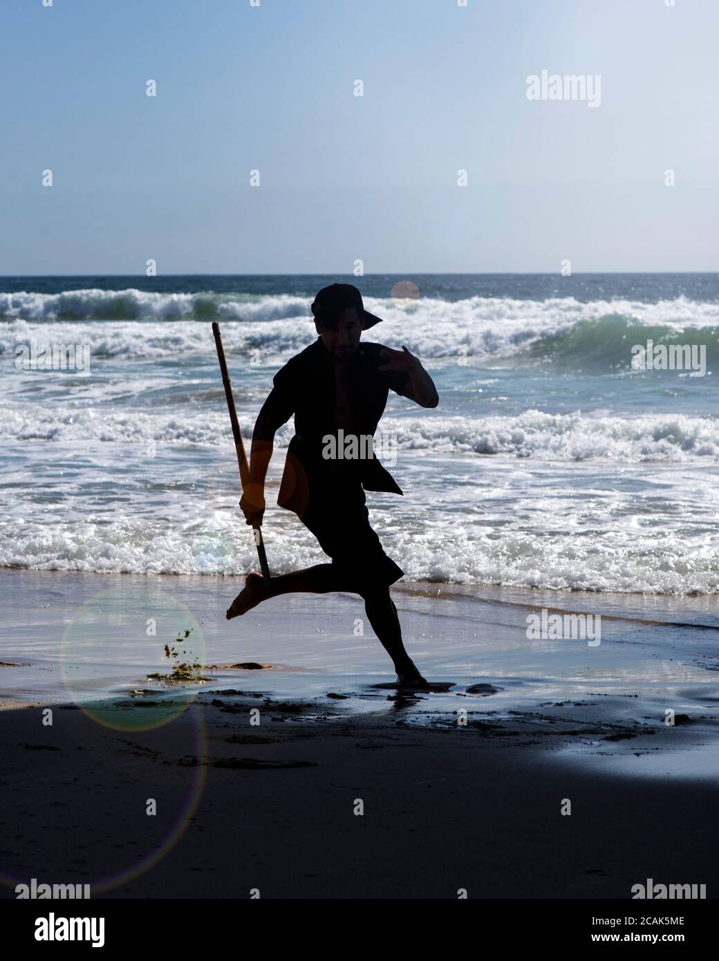 Ein junger Mann, der am Strand am wunderschönen Meer tanzt. Reisen, Tourismus Tanz und Unterhaltung. Stockfoto