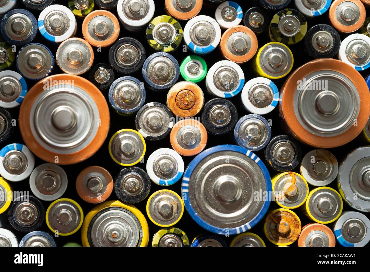 Nahaufnahme von positiven Enden entladener Batterien in verschiedenen Größen und Formaten, selektiver Fokus. Gebrauchte Batterie mit Korrosion und Rost. Gefährliche gar Stockfoto