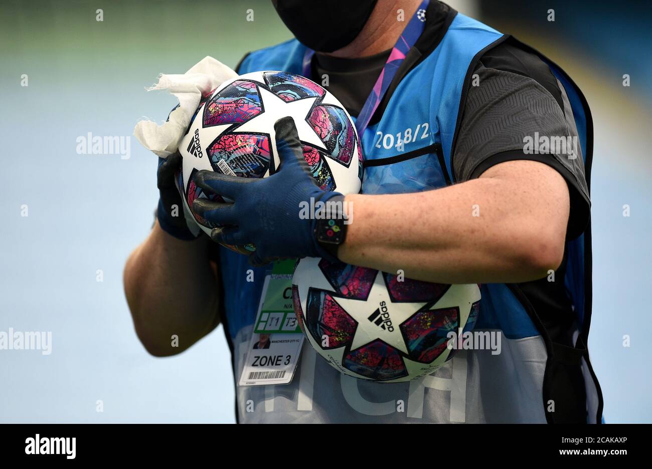 Ein Bodenmitarbeiter desinfiziert den Tagesball vor dem UEFA Champions League-Spiel, dem 16. Lauf, dem zweiten Beinspiel im Etihad Stadium, Manchester. Freitag, 7. August 2020. Siehe PA-Geschichte SOCCER man City. Das Foto sollte lauten: Oli Scarf/NMC Pool/PA Wire. Stockfoto