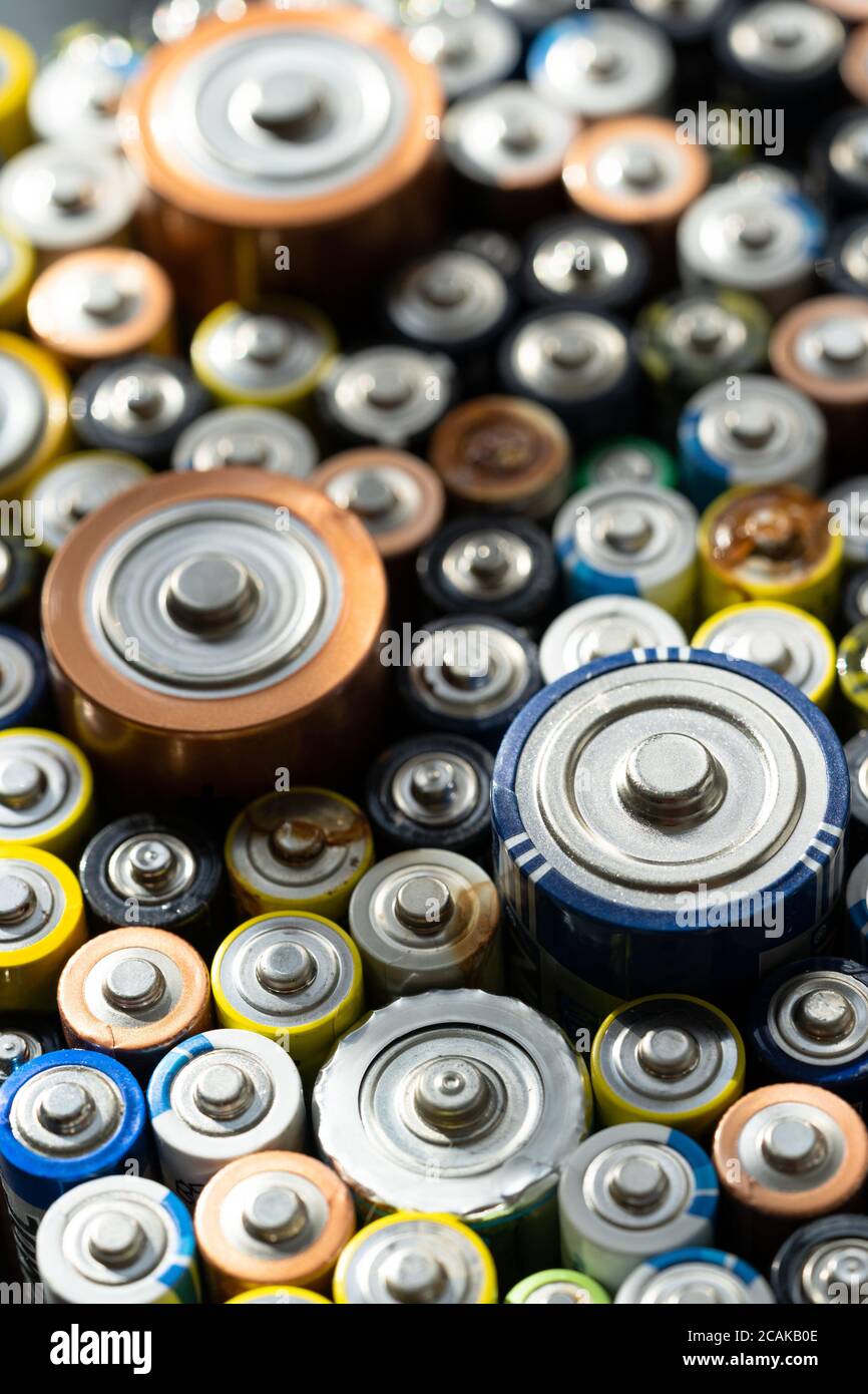 Nahaufnahme von positiven Enden entladener Batterien in verschiedenen Größen und Formaten, selektiver Fokus. Gebrauchte Batterie. Konzept des gefährlichen Mülls Stockfoto