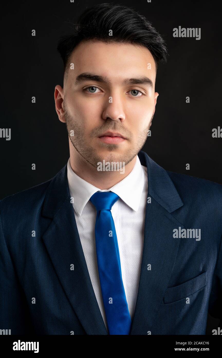 Porträt eines Geschäftsmanns mit blauem Business-Anzug und Krawatte Isoliert auf schwarzem Hintergrund Stockfoto