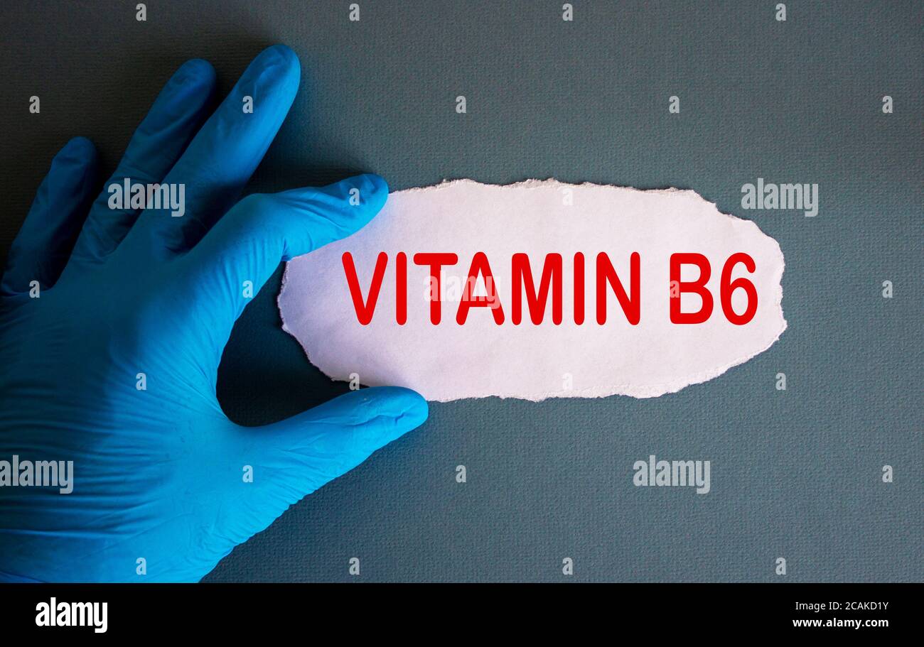 Hand in blauem Handschuh mit weißem Papier. Konzept Wort Vitamin b6. Stockfoto