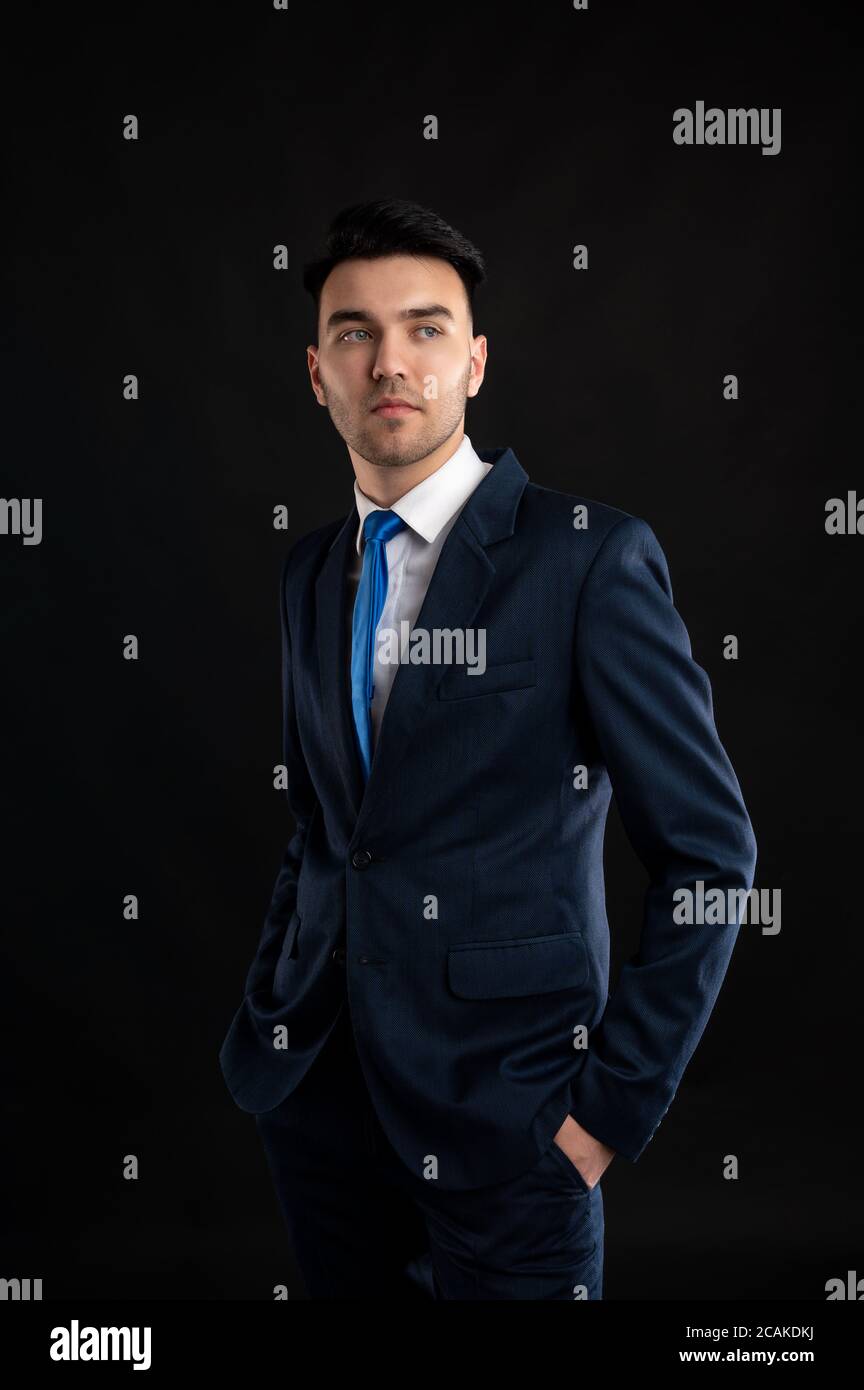 Porträt eines Geschäftsmanns mit blauem Business-Anzug und Krawatte Isoliert auf schwarzem Hintergrund Stockfoto