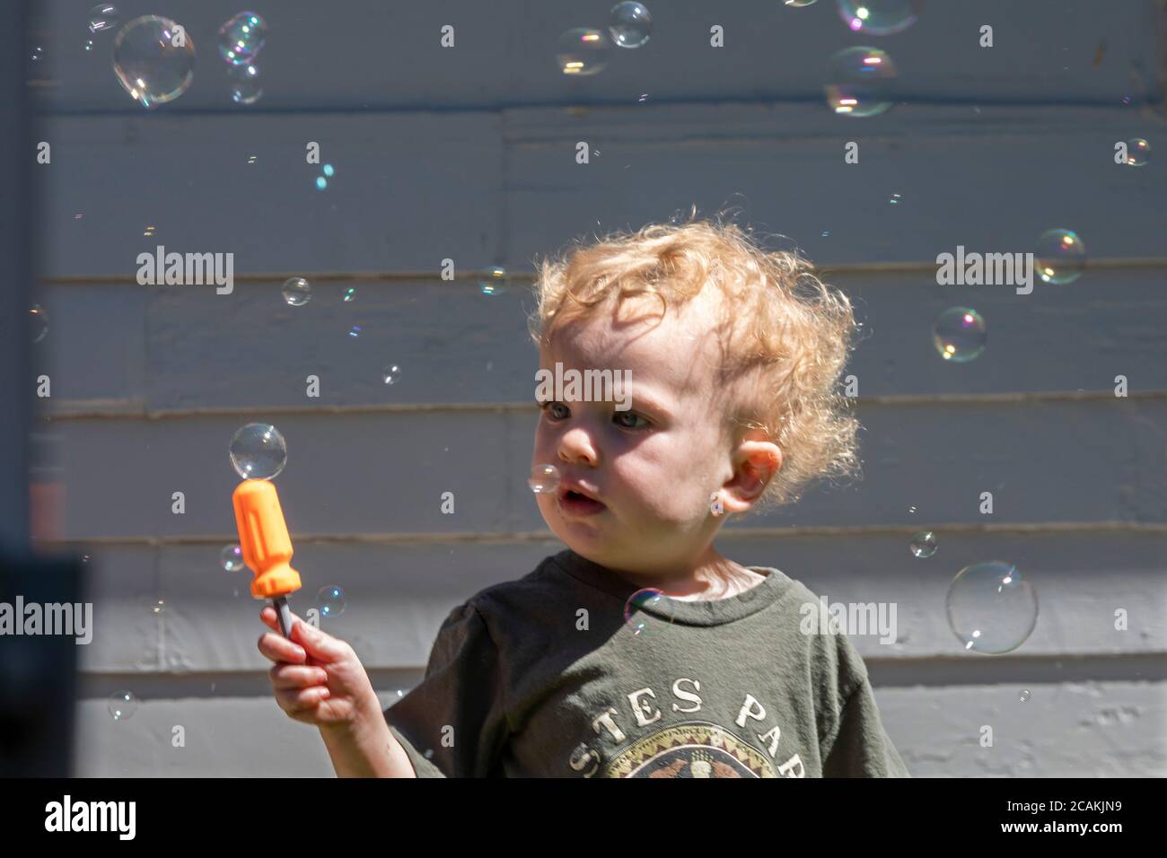 Denver, Colorado - die zweijährige Hendrix Hjermstad ist fasziniert von Blasen, die durch eine Blasenmaschine entstehen. Stockfoto