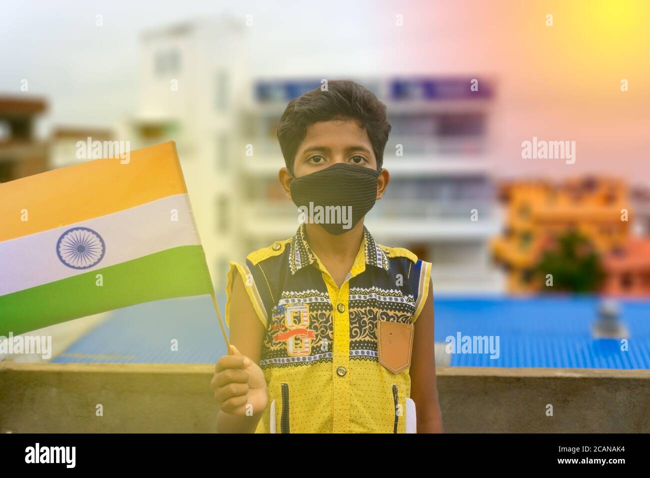 MASKE TRAGEN UND INDIANERFLAGGE HALTEN Stockfoto