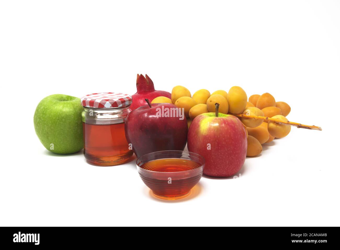 Rosh Hashanah, Jüdisches Neujahr, traditionelle Symbole, Honig im Glas, Granatäpfel, Datteln, rote und grüne Äpfel. Isoliert auf WEISSEM Hintergrund Stockfoto