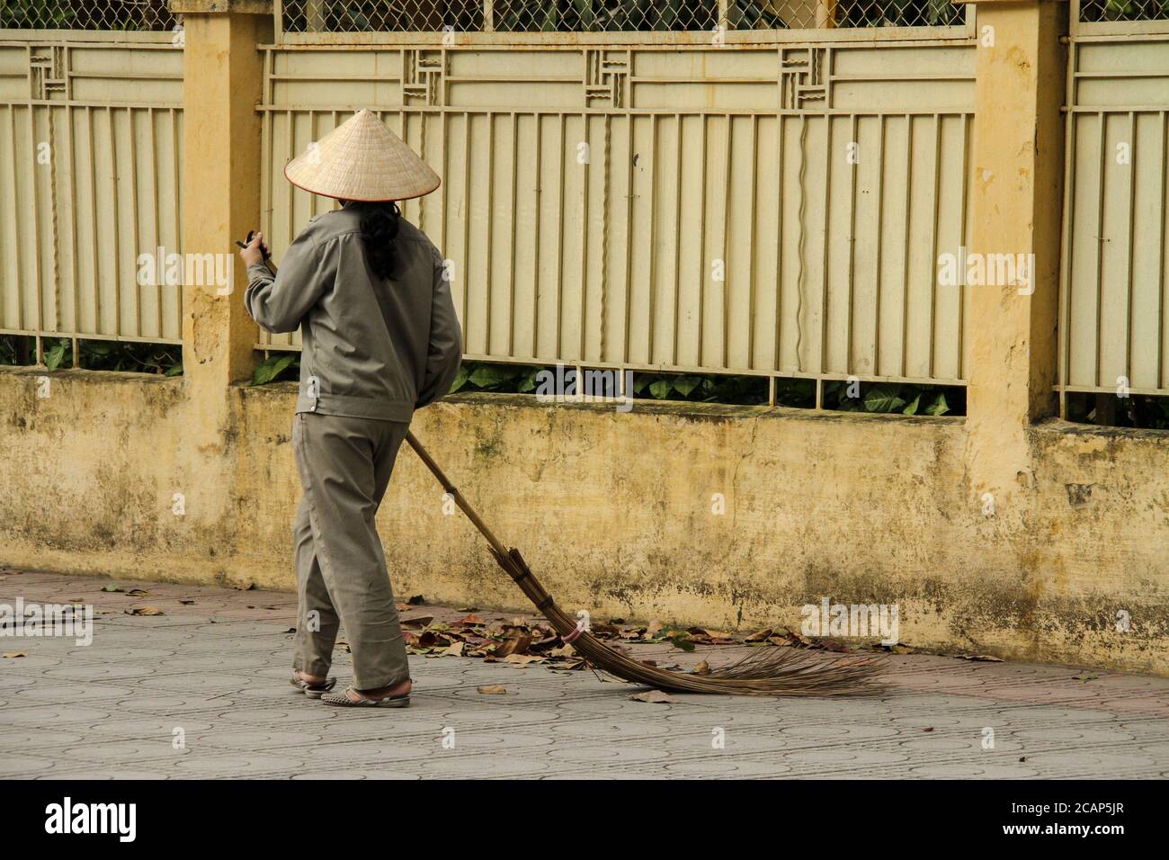 Weibliche Straßenputzerin in Hanoi Stockfoto