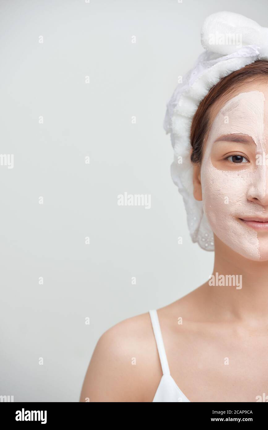 Porträt von jungen attraktiven asiatischen Frau mit Gesichtsmaske Ton auf weißem Hintergrund. Stockfoto