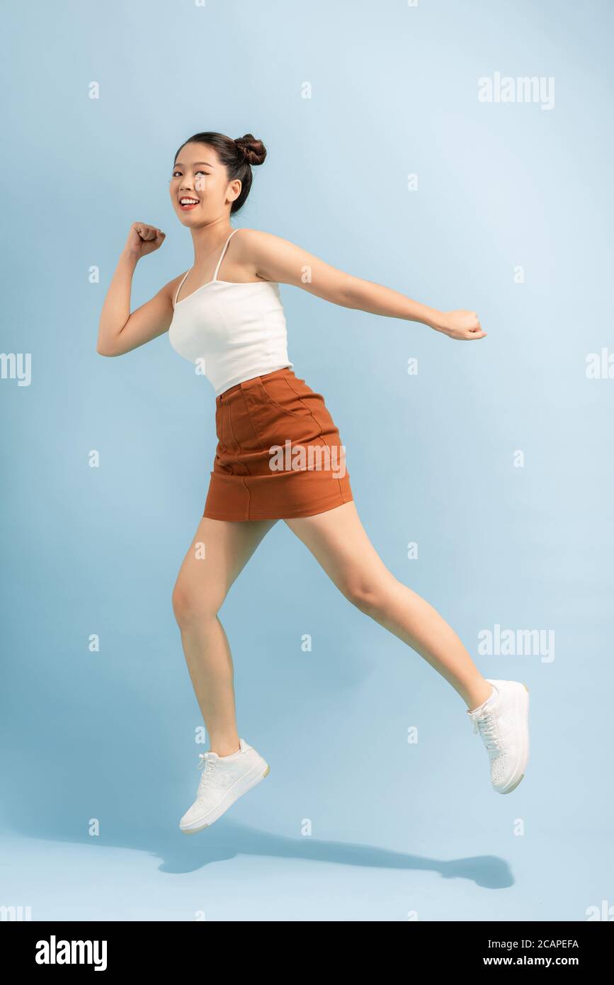 Ganzkörper-Foto von fröhlich aufgeregt energischen Mädchen springen genießen Frühling Freizeit Urlaub Wochenende isoliert über hellen Hintergrund Stockfoto