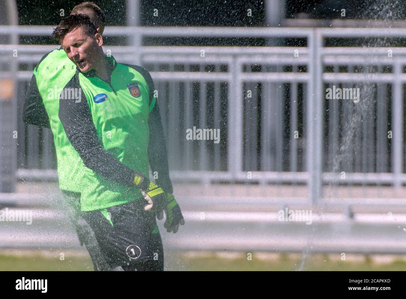 Heidenheim, Deutschland. August 2020. Torhüter Kevin Müller wird beim Trainingsstart des 2. Liga-Klubs FC Heidenheim vom Rasensprenger duschen. Quelle: Stefan Puchner/dpa/Alamy Live News Stockfoto