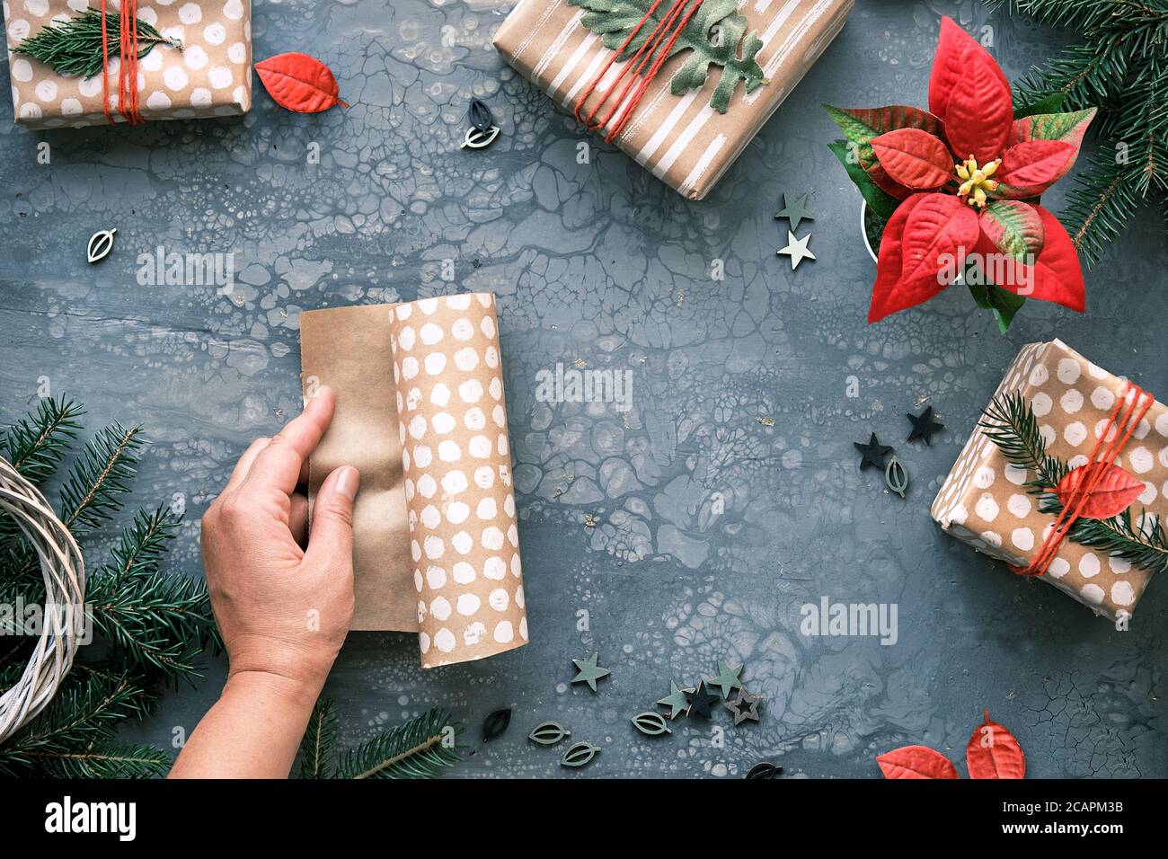 DIY Weihnachtsgeschenke und handgemachte Dekorationen. Natürliche Kunststoff kostenlos umweltfreundliche Weihnachtsfeier. Basteln Sie Geschenkpapier in den Händen. Flach liegend, Draufsicht auf Stockfoto
