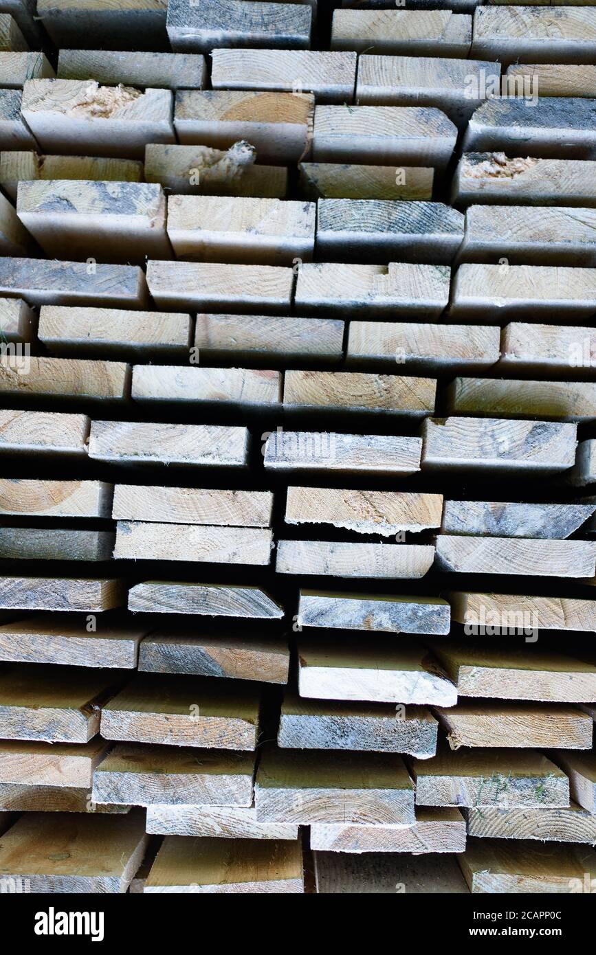 Stapel von Brettern in einem Lager. Gestapelte Holzbalken von rechteckigem Abschnitt. Stockfoto
