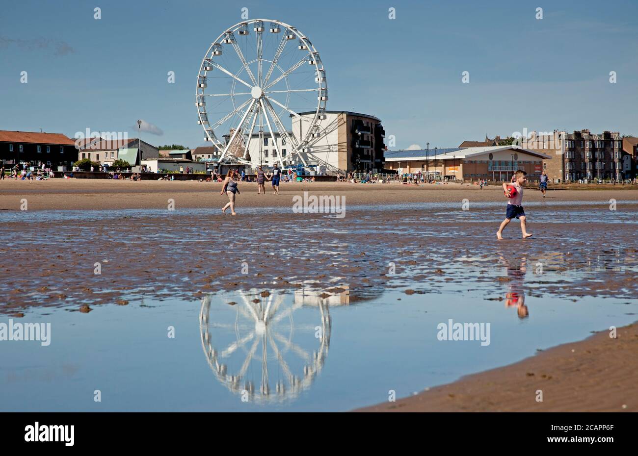 Portobello Beach, Ferris Wheel, Edinburgh, Schottland, Großbritannien. August 2020. Heiß und sonnig am Meer 17 Grad am Mittag brachten Familien heraus, um das Wetter und die Aktivität auf dem Firth of Forth zu genießen. Das Riesenrad ist eine neue Attraktion, von der jeder spricht Stockfoto