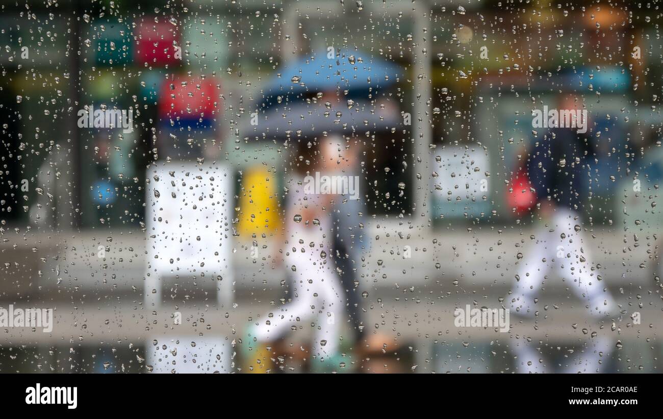 Menschen mit Regenschirmen unterwegs Stockfoto