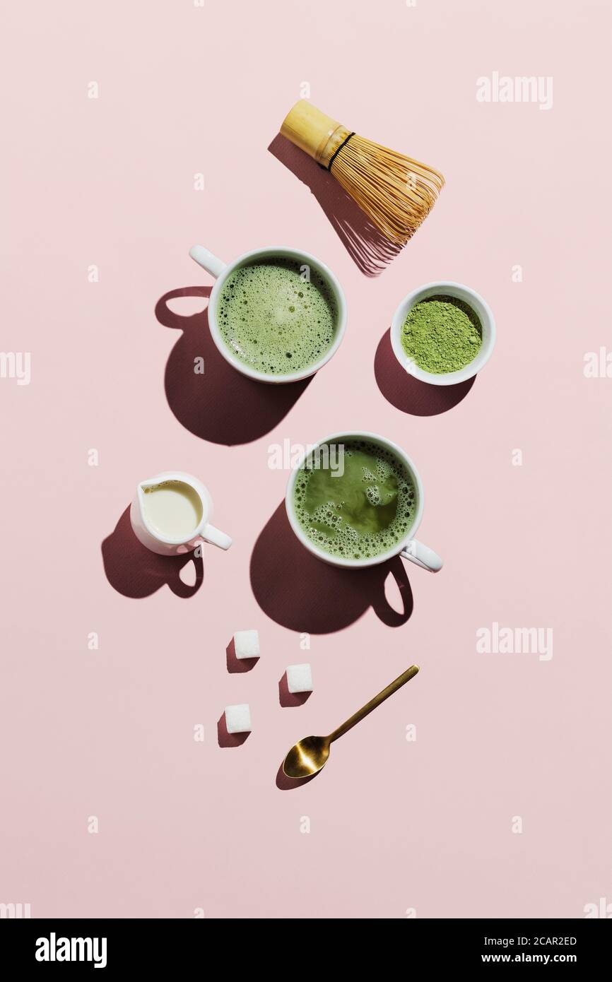 Vegane Matcha Latte mit Hafermilch auf rosa Stockfoto