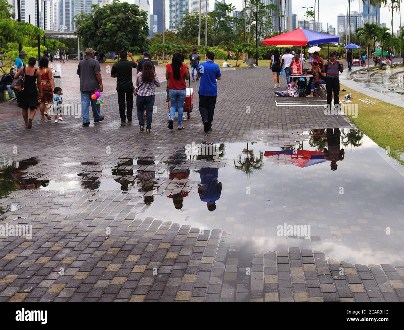 Reflexion in Regenwasserpfütze von Menschen, die am autofreien Sonntag, panama City, Panama, Mittelamerika spazieren Stockfoto