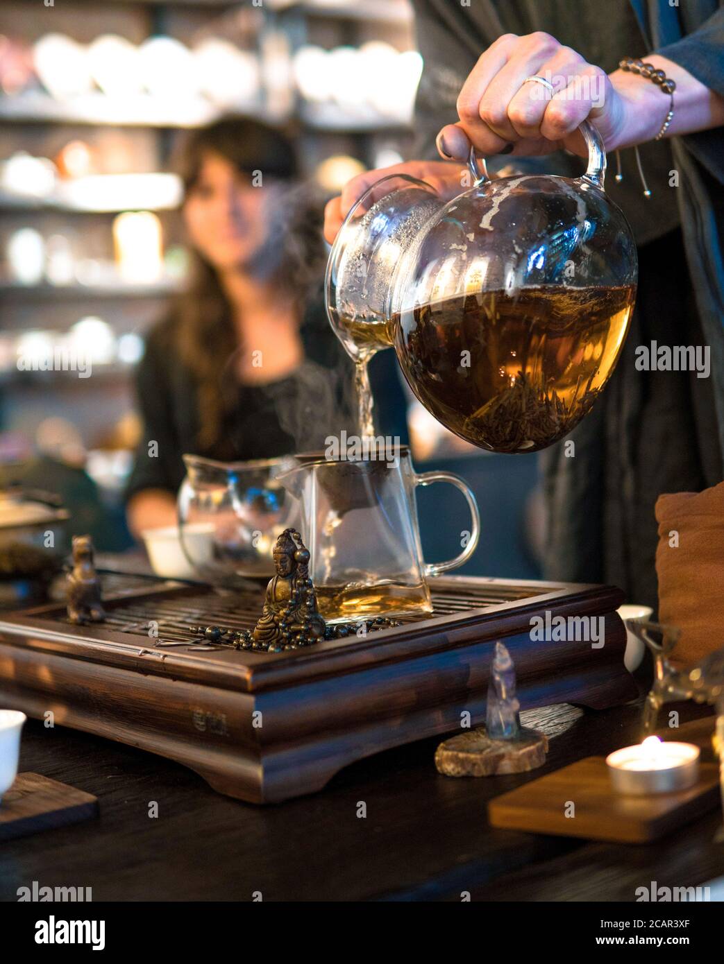 Traditionelle Chinesische Teezeremonie. Schwarzer oder roter Tee Gießen aus Glas große Teekanne in Glas Chahai auf dunklen Holztisch Hintergrund Stockfoto