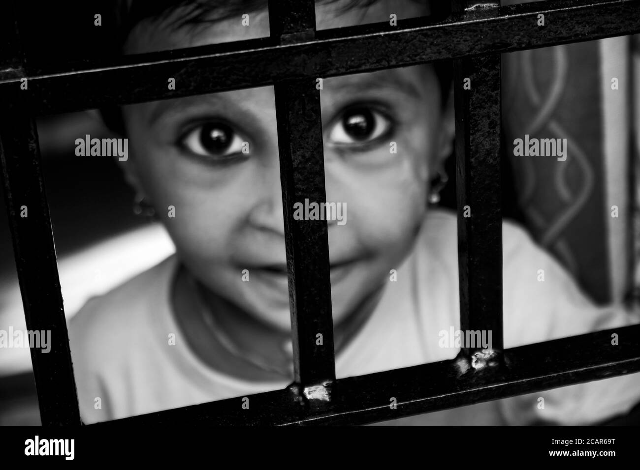 Ein Mädchen, das im Fenster Inder Lock-down Situation Zeit genießt, Kalaburagi, Karnataka/Indien-Juli 07.2020 Stockfoto