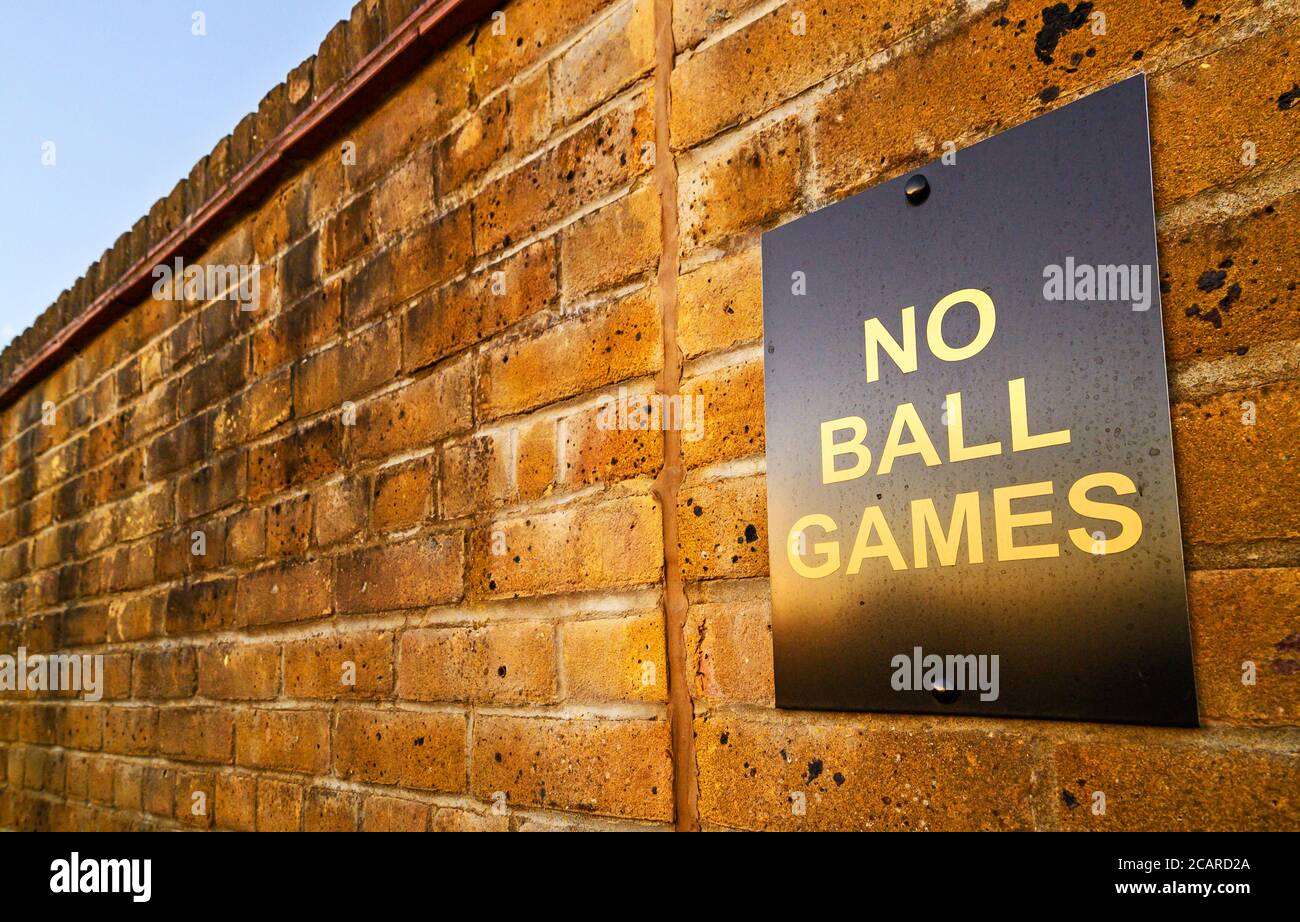 Kein Ball Games Zeichen auf einer Mauer. Auf diesem Teil einer Wohnanlage sind keine Ballspiele erlaubt. Schild an einer Wand bei Sonnenuntergang. Stockfoto
