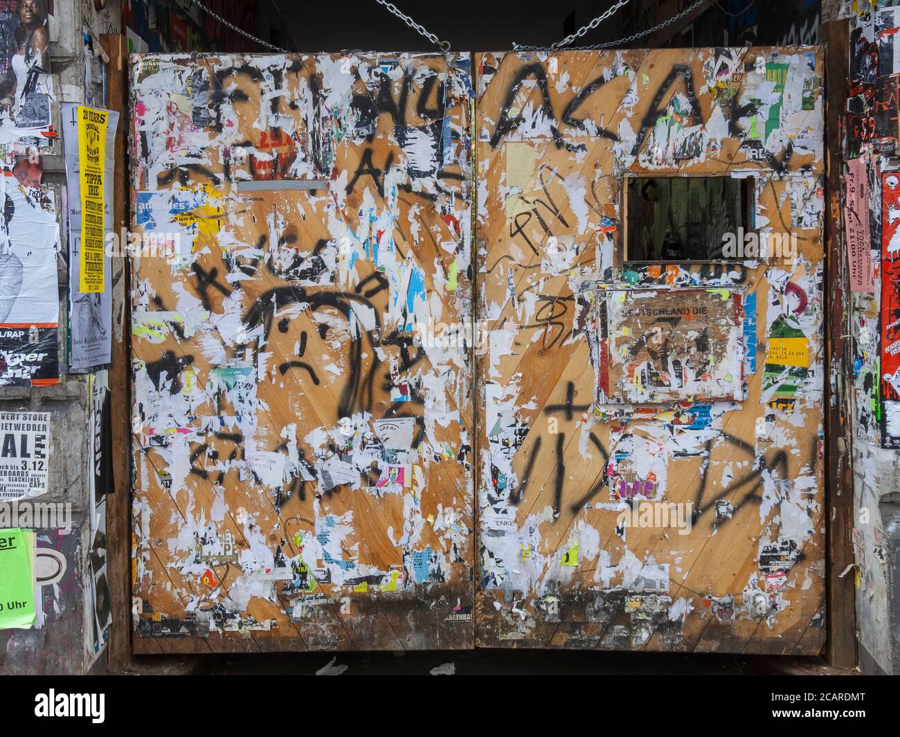 Plakatreste und Graffiti an den Türen eines Tores in der Schanzenstraße, Hamburg, Deutschland. Stockfoto