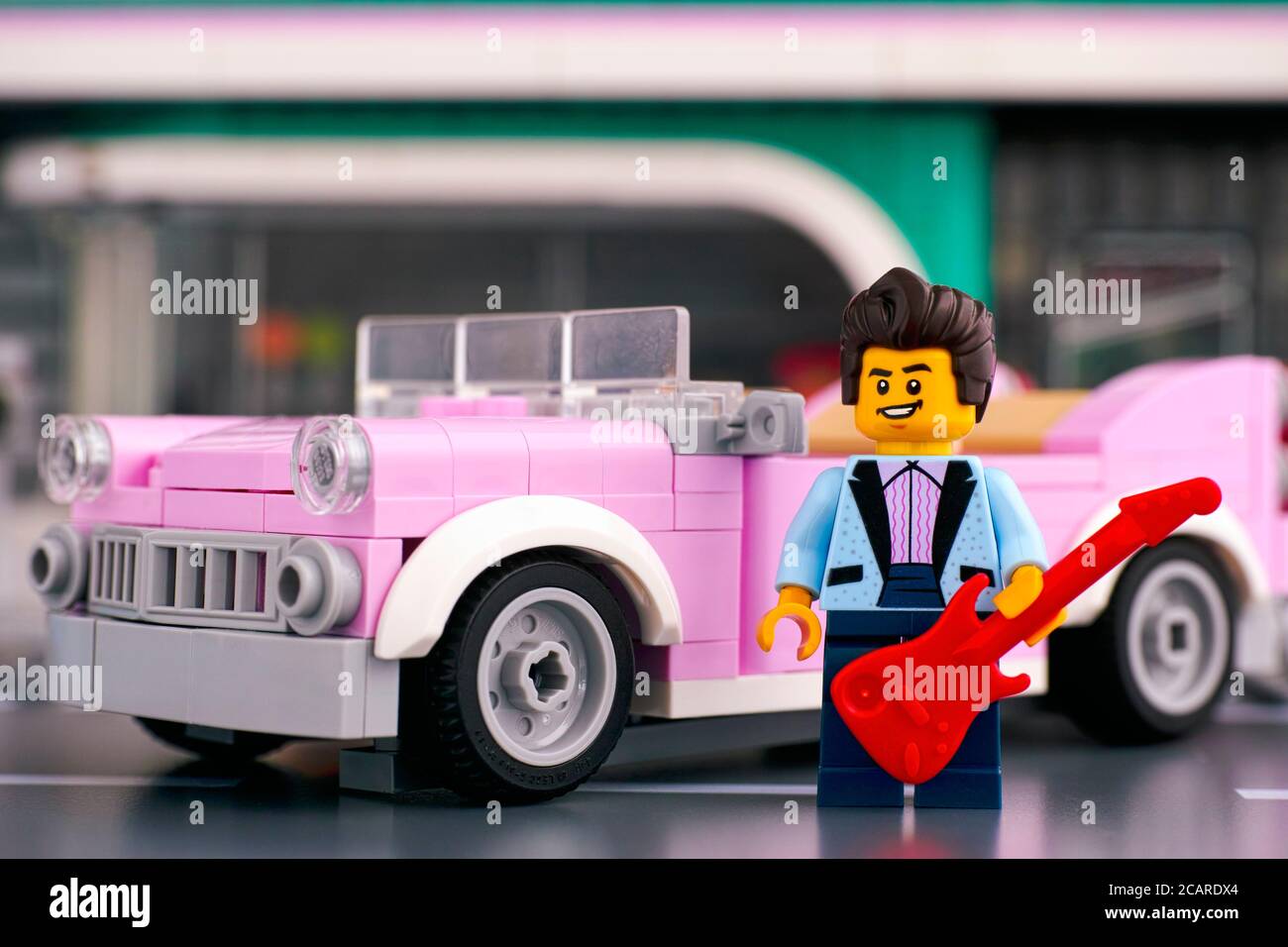 Tambov, Russische Föderation - 22. Januar 2020 Lego Rock-n-Roll Star Minifigur mit Gitarre fast rosa 50er Jahre-Stil Cabrio. Stockfoto