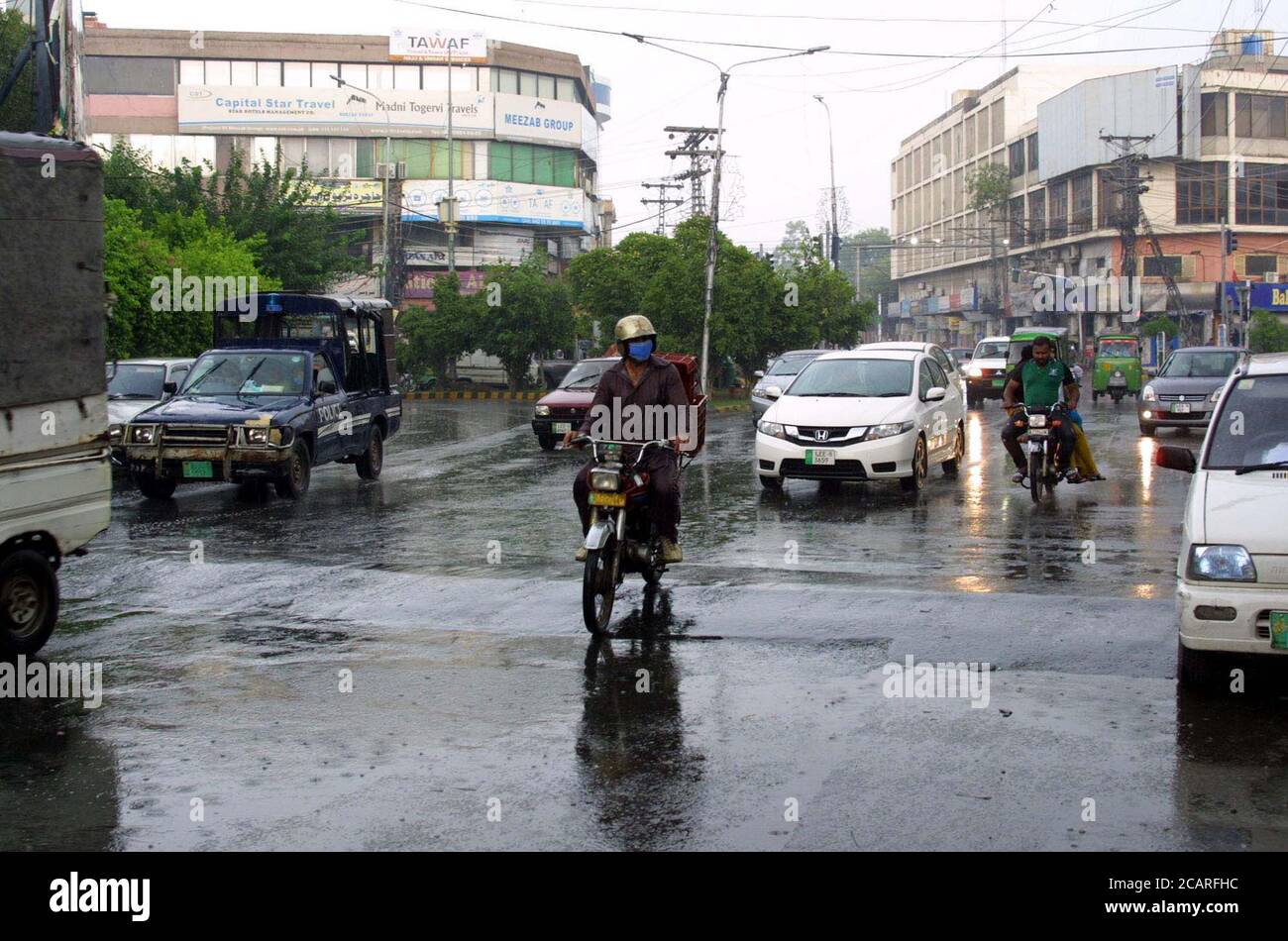 Pendler fahren während der Monsunsaison auf dem Shimla Hill in Lahore am Samstag, den 8. August 2020, durch eine Straße. Stockfoto