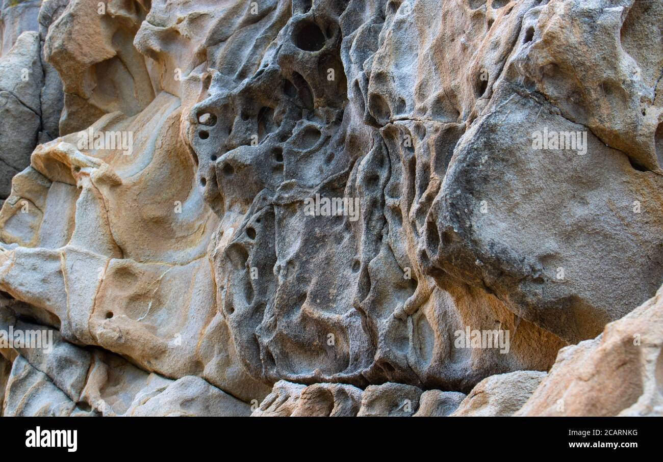 Textur, Hintergrundschichten und Risse im Sedimentgestein an der Felswand. Klippe des Felsbergs. Felsschiefer in den Bergen. Nahtlose Abstraktion Stockfoto