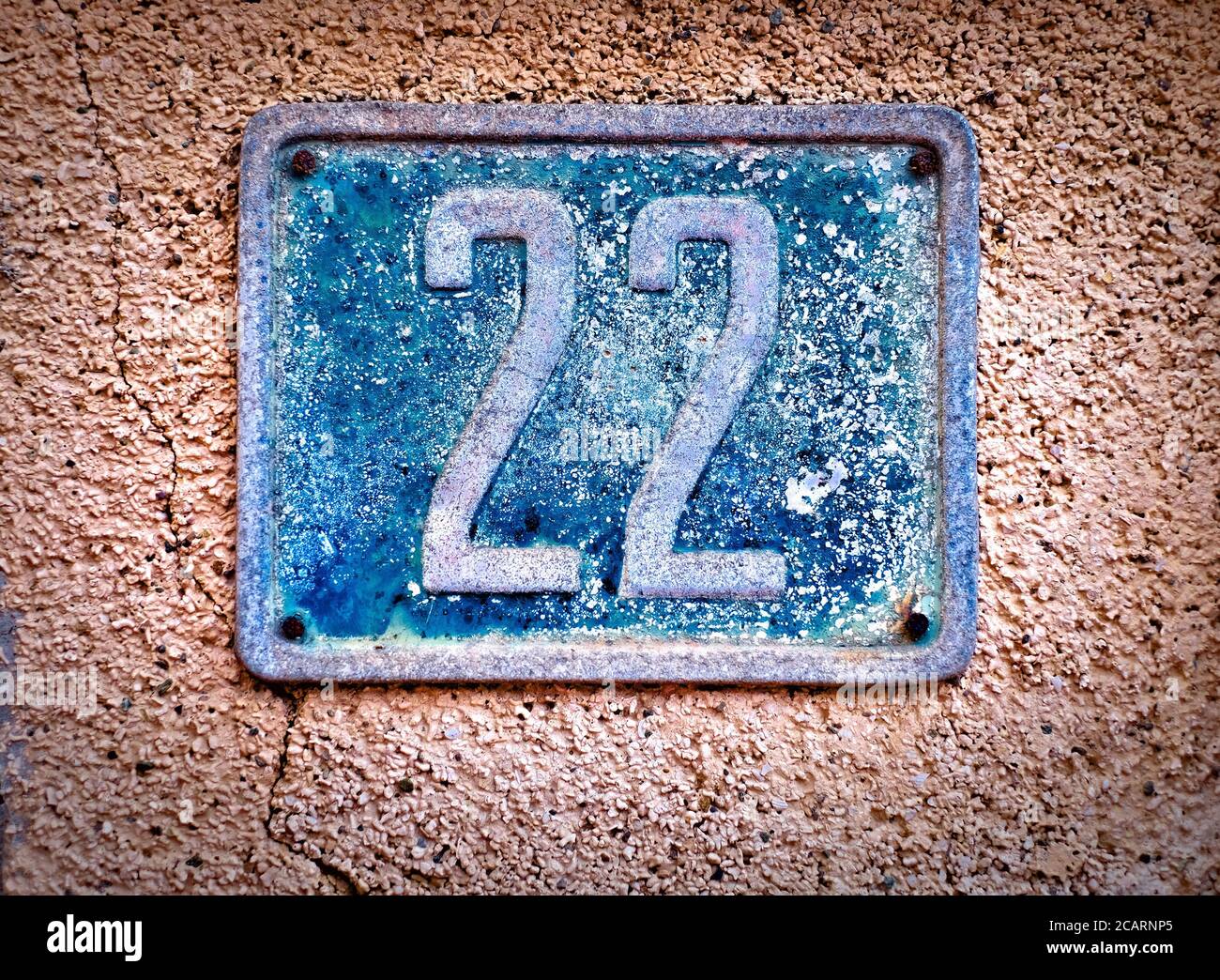 22, Nummer zweiundzwanzig, altes blaues Metallschild an einer Wand. Stockfoto