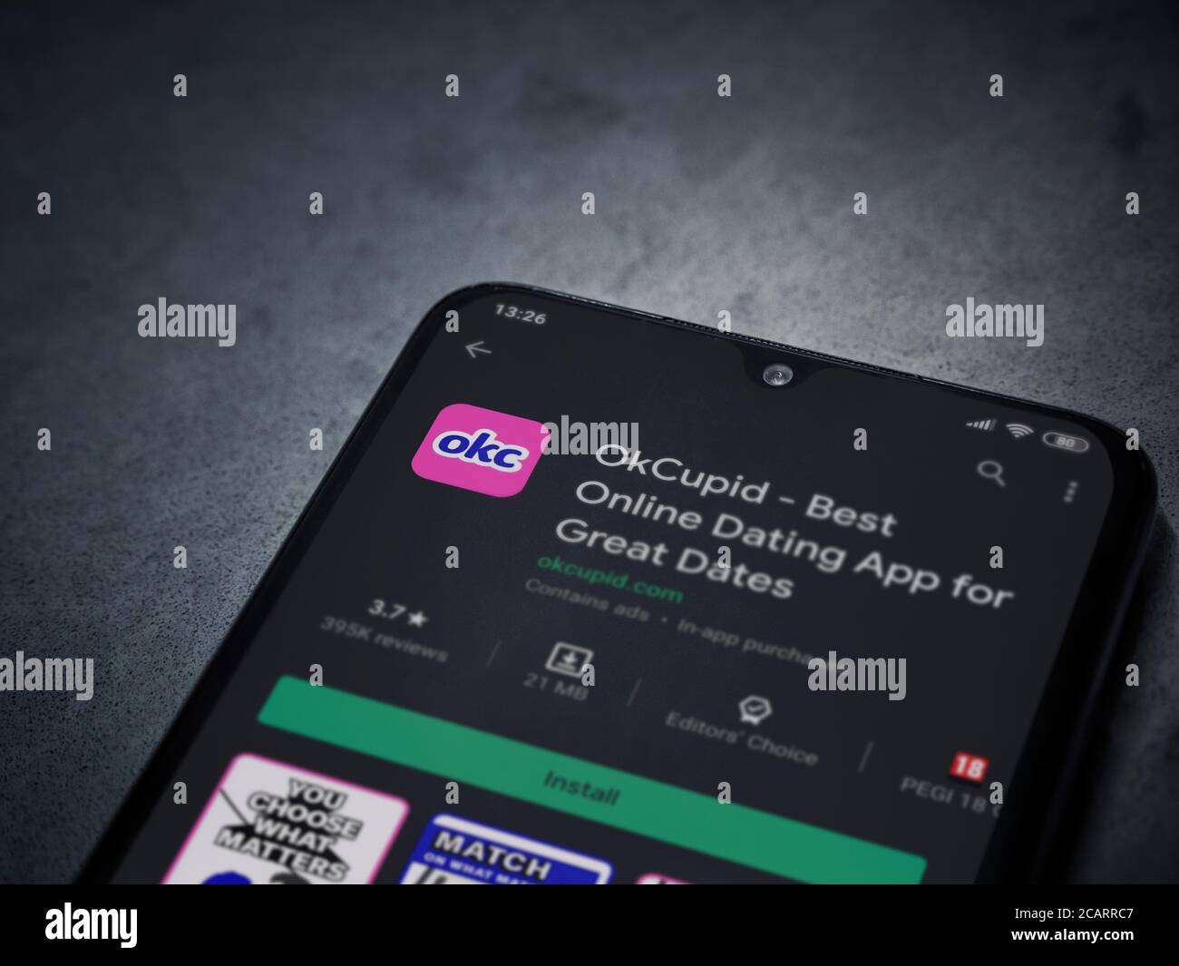 LOD, Israel - 8. Juli 2020: OkCupid App Play Store-Seite auf dem Display eines schwarzen Smartphone auf dunklem Marmor Stein Hintergrund. Draufsicht flach liegend Stockfoto
