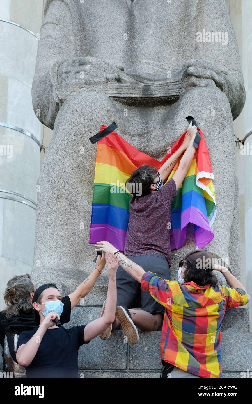 Warschau, Polen - Samstag, 8. August 2020 - LGBT-Aktivisten und Unterstützer bringen am Samstagabend im Kulturpalast im Zentrum von Warschau eine LGBT-Regenbogenfahne auf eine Statue des Sozialrealismus ( kommunistische Ära ), während eine Demonsration die Gleichberechtigung und ein Ende der Diskriminierung in Polen fordert. Die PiS-Parteiregierung und Präsident Duda stehen der polnischen LGBT-Gemeinschaft feindlich gegenüber. Foto Steven May / Alamy Live News Stockfoto