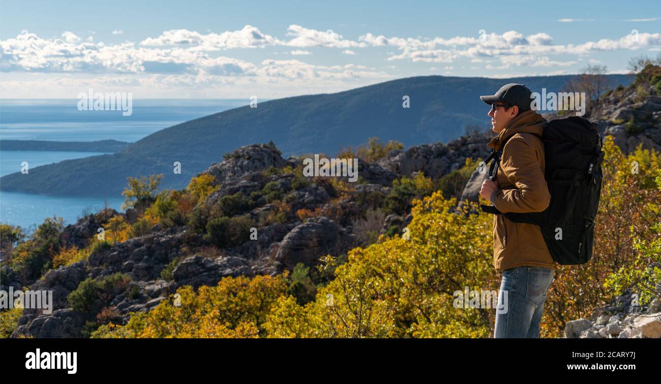 Ein Reisender mit Rucksack steht auf der Oberseite Der Berg Stockfoto