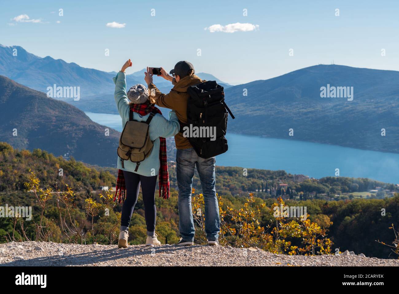 Ein paar Reisende mit einem Smartphone auf dem Gipfel eines Berges. Stockfoto