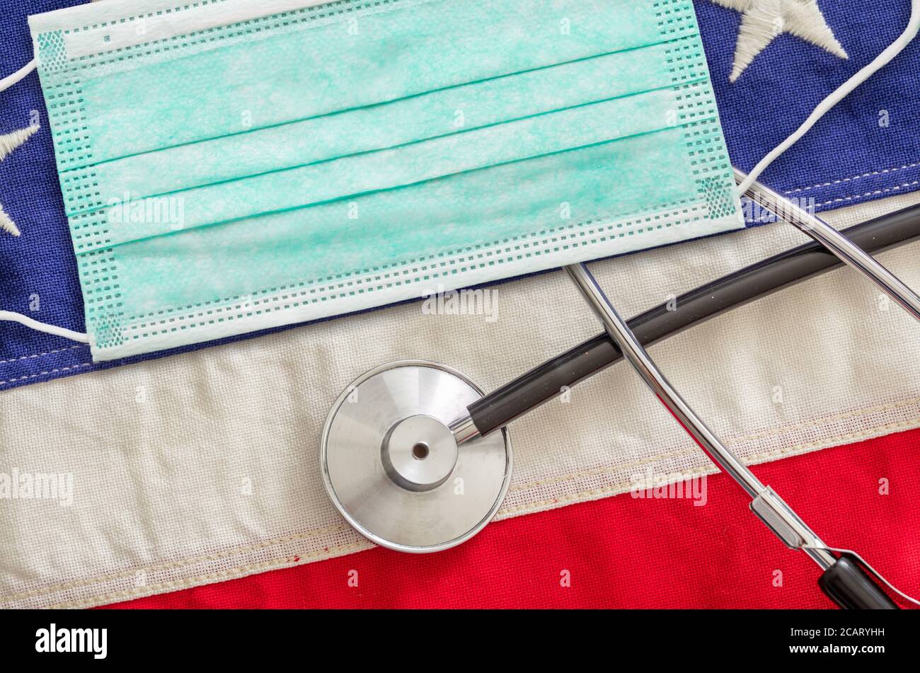 Coronavirus Covid 19 in den USA. Schutzmaske und medizinisches Stethoskop auf US-amerikanischer Flagge Hintergrund. Stockfoto
