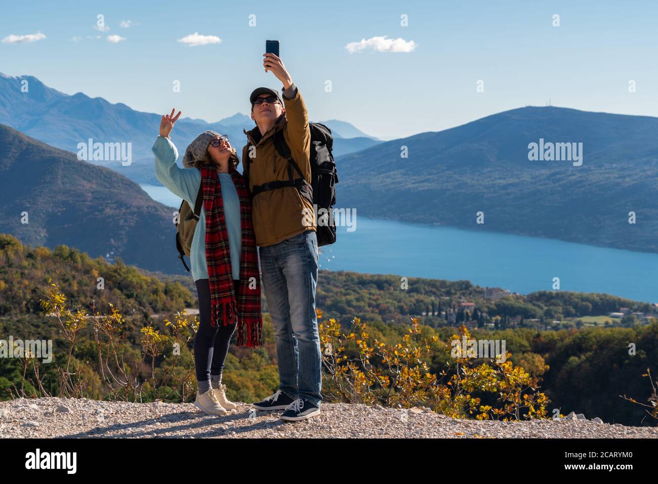 Ein paar Reisende mit einem Smartphone auf dem Gipfel eines Berges. Stockfoto