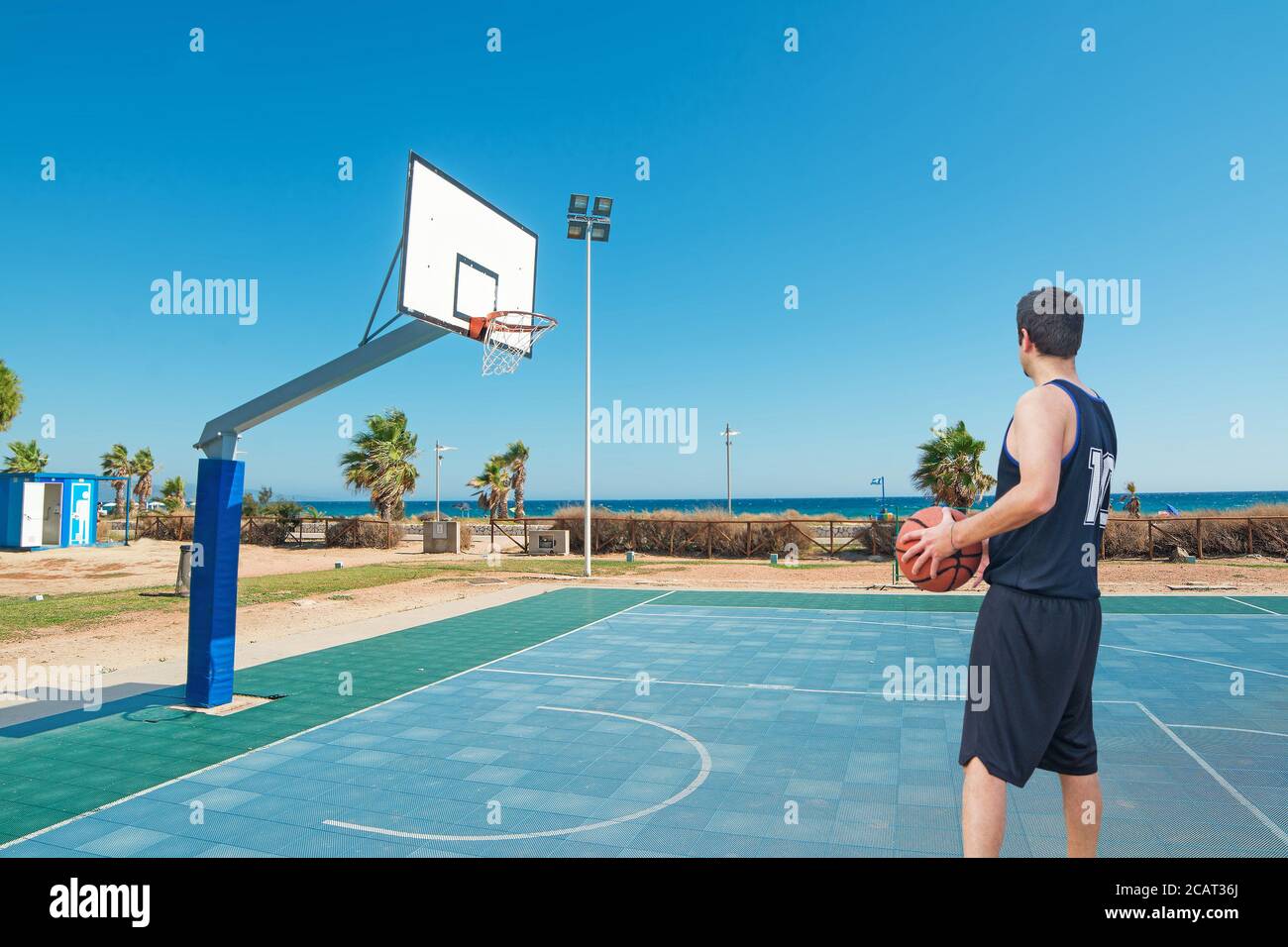 Basketballspieler steht auf einem blauen Spielplatz Stockfoto