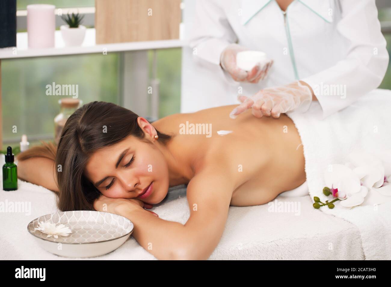 Junge kaukasische Brünette weiblich beschließt, ihren Tag mit der Behandlung selbst zu einer entspannenden Massage in Wellness-Klinik beginnen. Gesunder Lebensstil und Spa Stockfoto