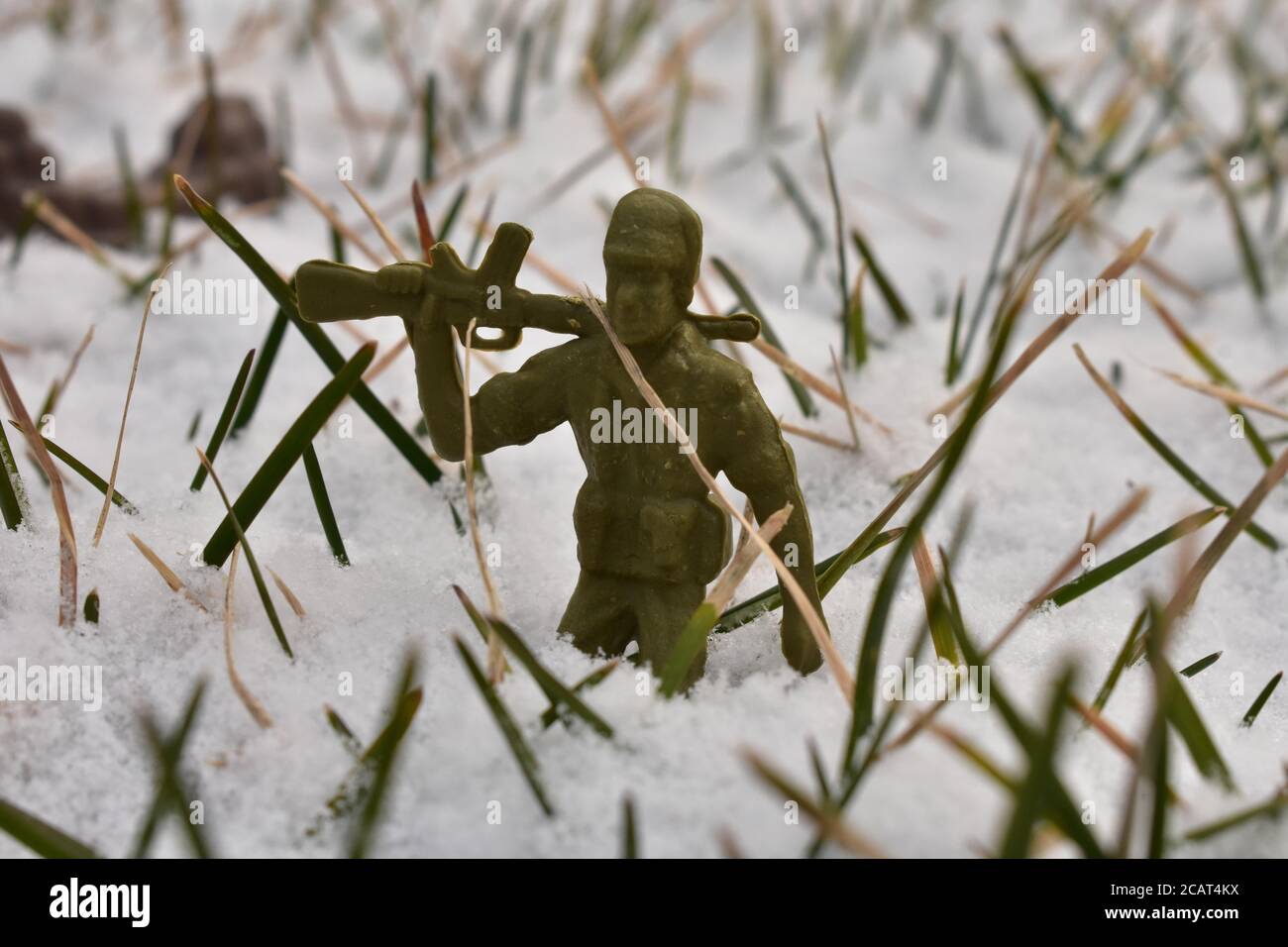 Ein Toy Soldier, der sein Gewehr auf seiner Schulter ausruht Knietiefer Schnee Stockfoto