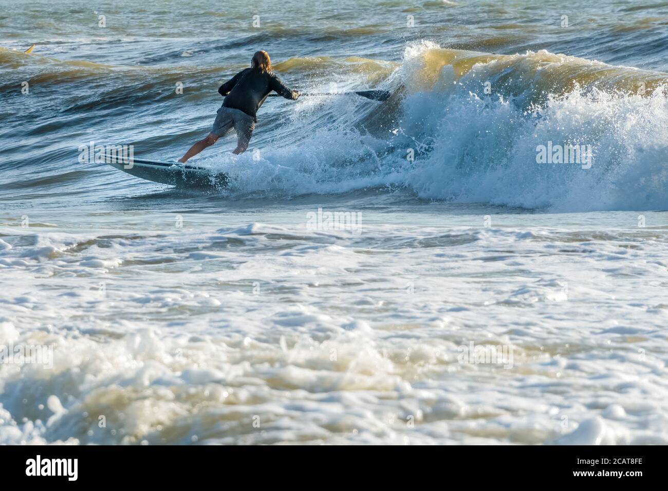 Paddelboarder beim Wellenreiten am Jacksonville Beach im Nordosten Floridas. (USA) Stockfoto