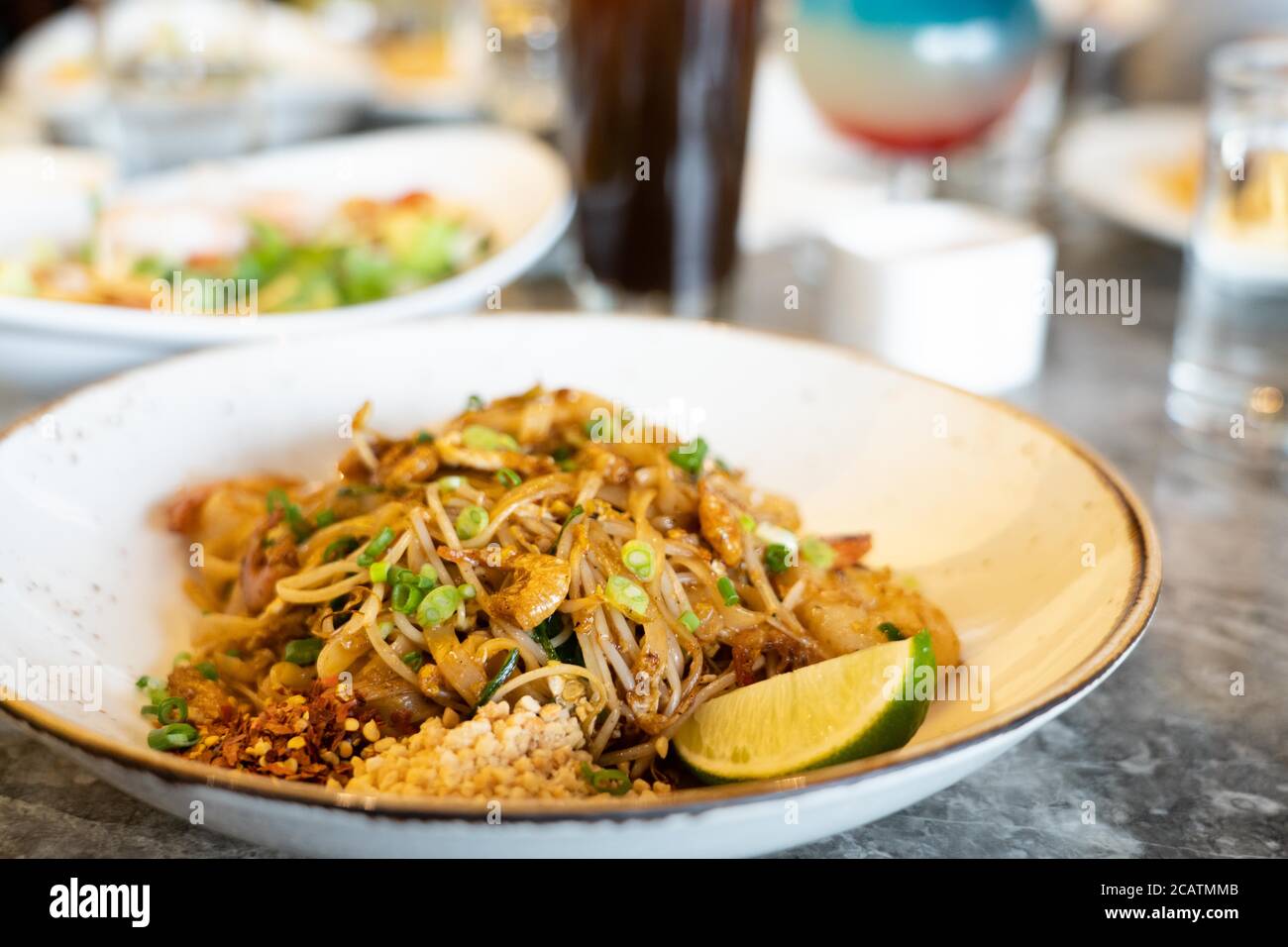 Nahaufnahme von Thailand traditionelle Street Food, Pad Thai Nudeln auf einem weißen Teller und Marmor Stein Tisch. Stockfoto