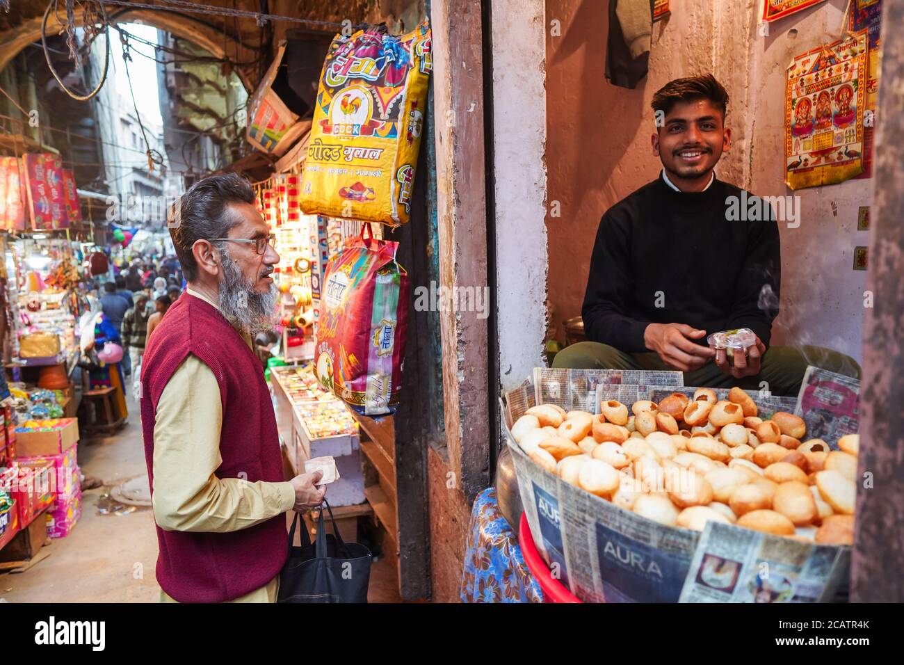 Agra / Indien - 22. Februar 2020: Junge Männer in Snack-Shop an kleinen Street Food-Stall in überdachten Marktstraße in Heritage Agra Innenstadt Stockfoto