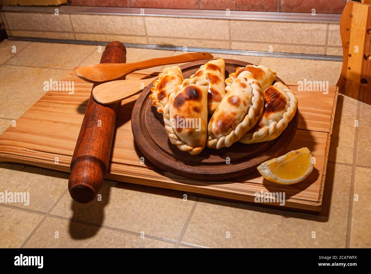 Holztisch mit frischen, hausgemachten Empanadas (detaillierte Nahaufnahme; selektive Fokus) Stockfoto