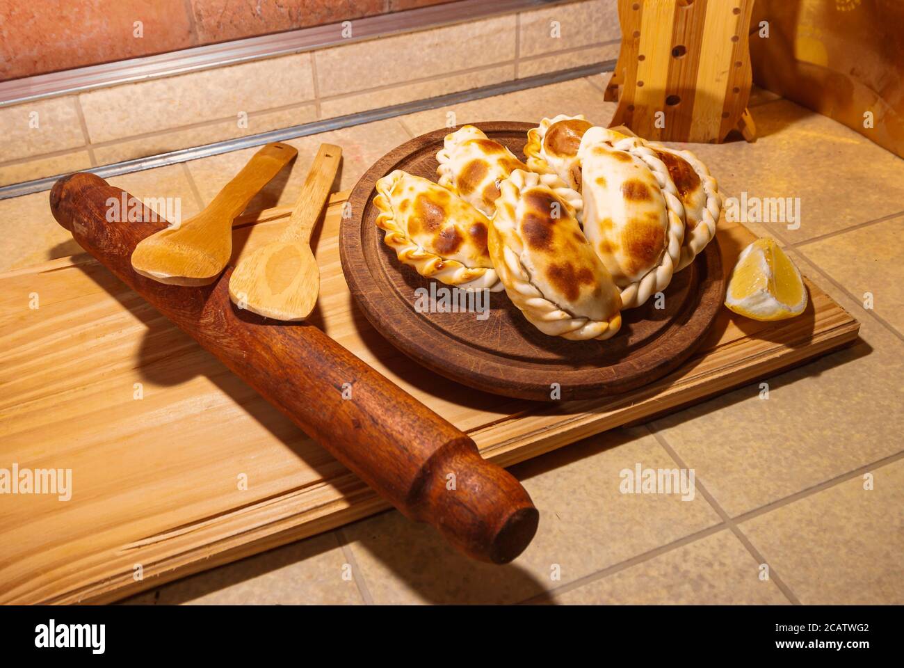 Holztisch mit frischen, hausgemachten Empanadas (detaillierte Nahaufnahme; selektive Fokus) Stockfoto