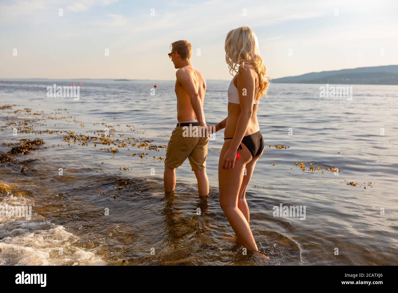 Romantisches Paar mit Händen und Spaziergänge am Meer Am Abend Stockfoto