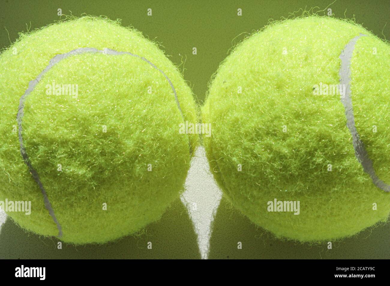 Zwei goldene Tennisbälle auf weißem Hintergrund Stockfoto