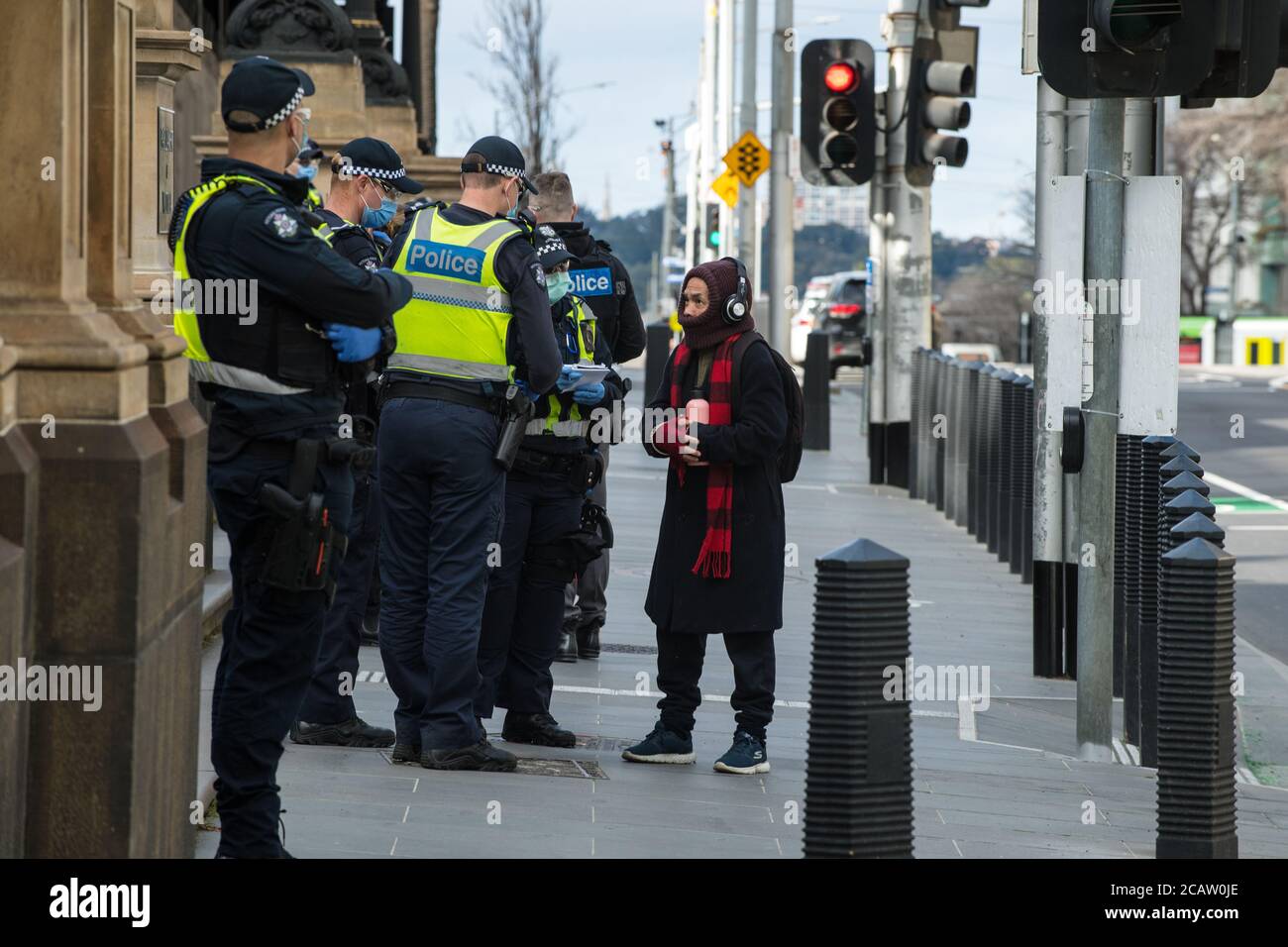 Melbourne, Australien 9. August 2020, viktorianische Polizisten eingesetzt, um Anti-Maske-Proteste zu begegnen, fragen ein Mitglied der Öffentlichkeit, die vor dem Landtag zu Fuß war. Kredit: Michael Currie/Alamy Live Nachrichten Stockfoto