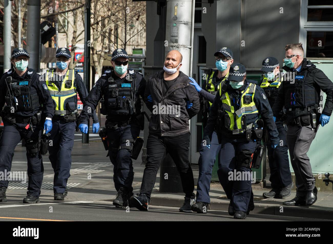 Melbourne, Australien am 9. August 2020 verhaften einige der zahlreichen viktorianischen Polizeibeamten, die gegen maskenfeindliche Proteste eingesetzt wurden, einen Mann, weil sie sich weigerten, eine Maske außerhalb des Landtags zu verhaften. Kredit: Michael Currie/Alamy Live Nachrichten Stockfoto