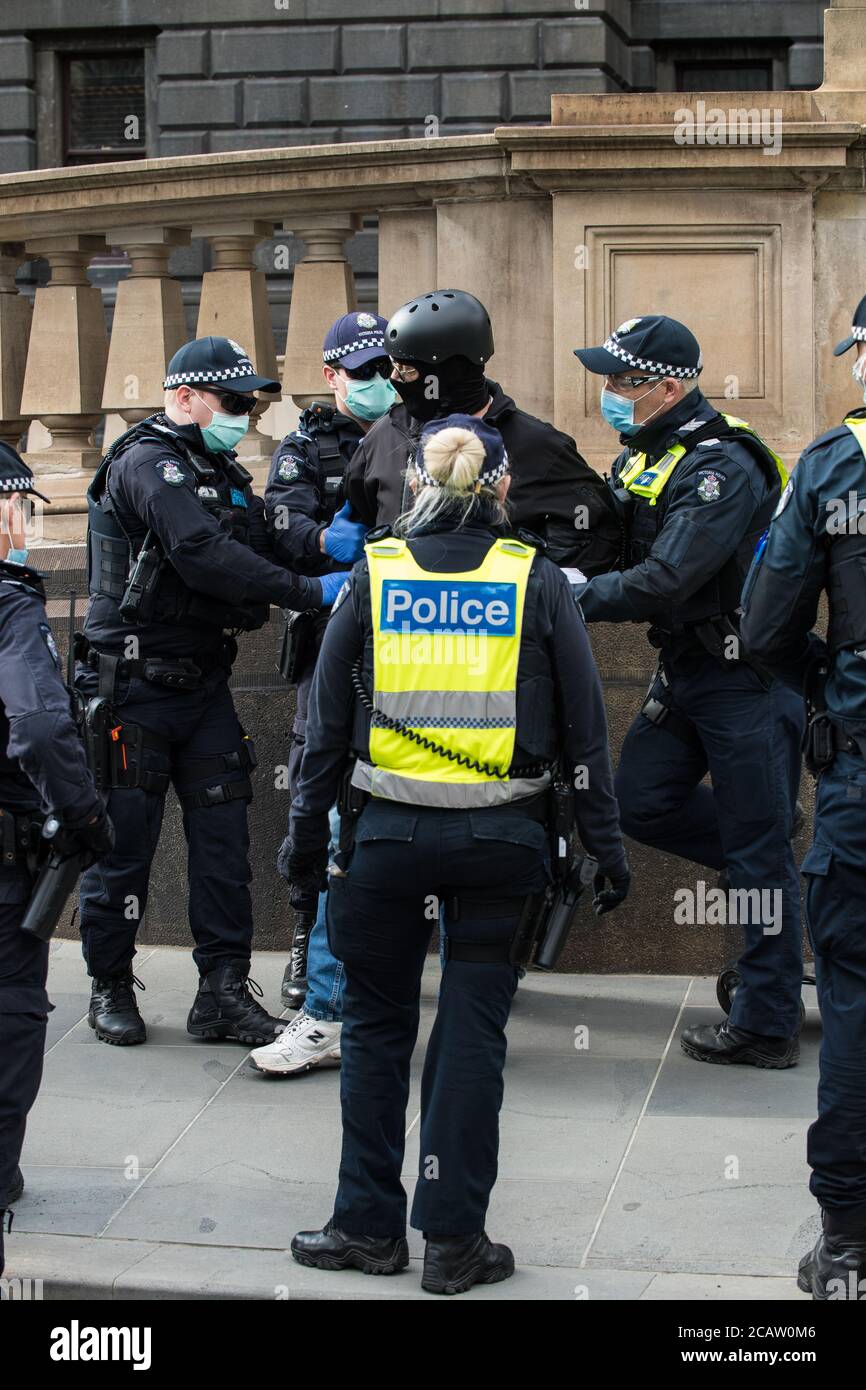 Melbourne, Australien 9. August 2020,Polizeibeamte von Victoria verhaften einen Mann, der sich geweigert hatte, der Polizei seine Daten zu geben, nachdem er nicht mehr mit einem elektrischen Skateboard gefahren war, außerhalb des Landtags, wo ein Anti-Maskenprotest geplant war. Kredit: Michael Currie/Alamy Live Nachrichten Stockfoto