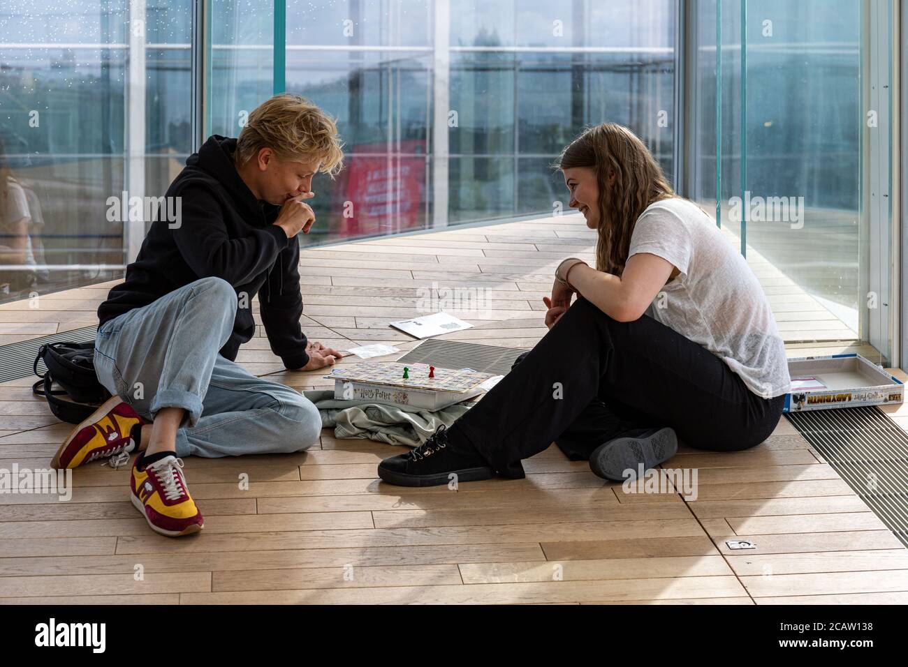 Junges Paar spielt ein Brettspiel in der Oodi Bibliothek in Helsinki, Finnland Stockfoto