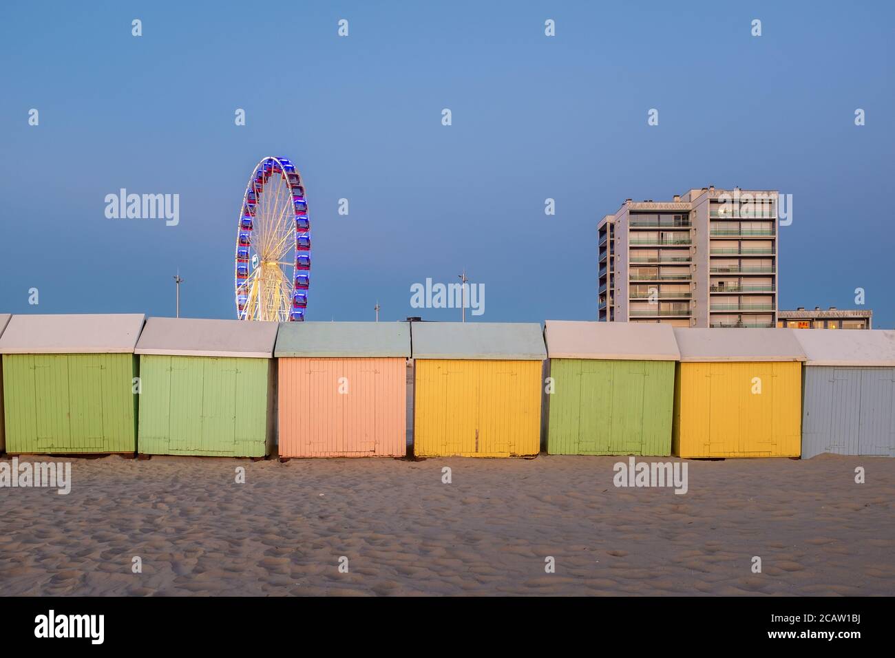 Pastellfarbene Strandhütten und Riesenrad am Strand Von Berck in Frankreich Stockfoto