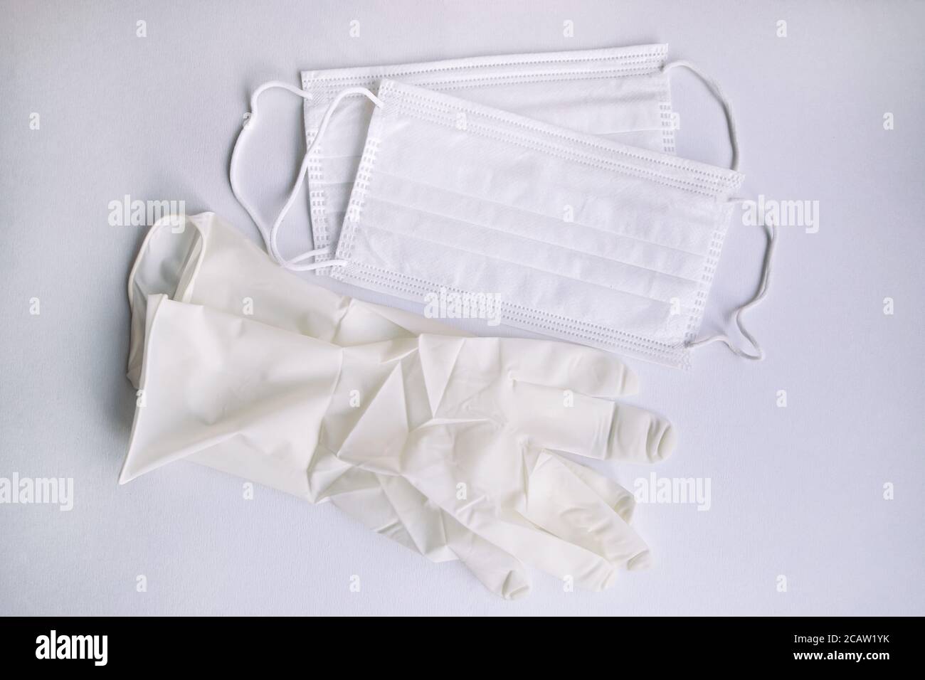 Medizinische Schutz Einweg weißen Masken und Handschuh auf weißem Hintergrund. Schutzausrüstung gegen Viren, Grippe und Coronaviren (COVID-19). Stockfoto